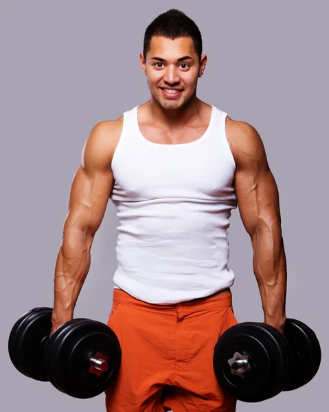 Ajuste o homem muscular exercitando com halteres — Fotografia de Stock