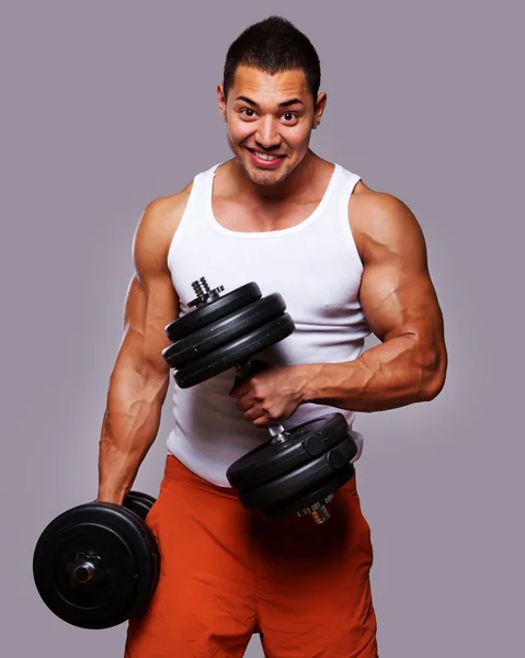 Ajuste o homem muscular exercitando com halteres — Fotografia de Stock