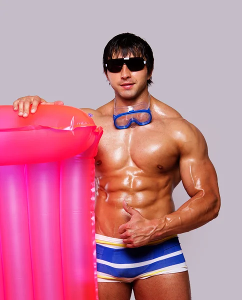 Portret seksowny mężczyzna pozowanie na plaży w okularach i z pin — Zdjęcie stockowe