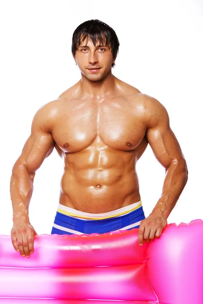 Portret van sexy man die zich voordeed op witte achtergrond met roze mattre — Stockfoto