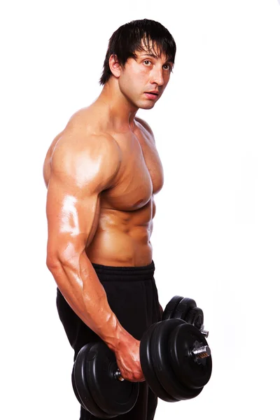 Портрет мускулистого человека, делающего упражнения с гантелями — стоковое фото
