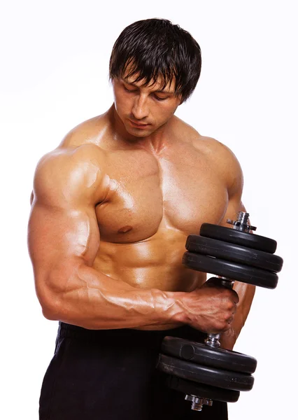 Портрет мускулистого человека, делающего упражнения с гантелями — стоковое фото