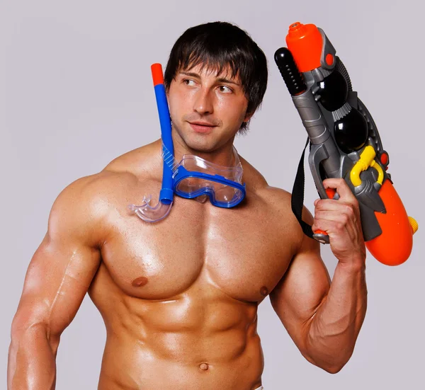Portrait of man with water gun posing in the beach — Stock Photo, Image