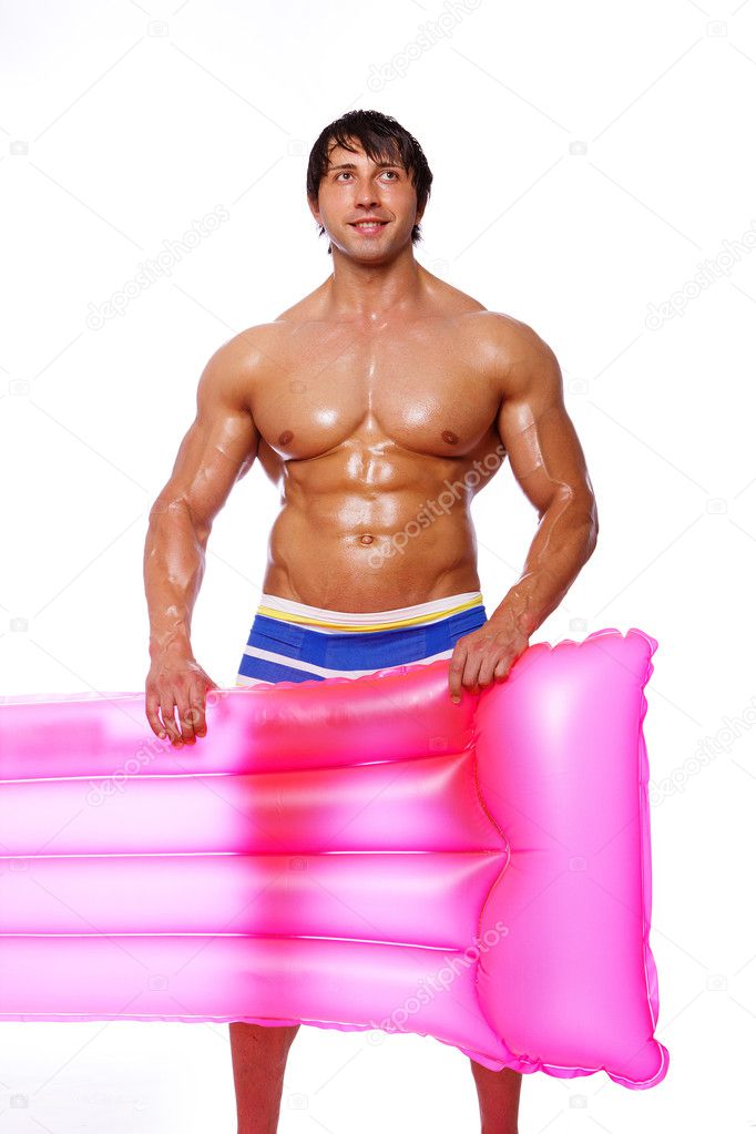 Portrait of sexy man posing on white background with pink mattre