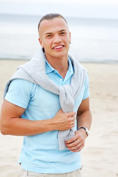 Portret człowieka na plaży w niebieską koszulkę — Zdjęcie stockowe