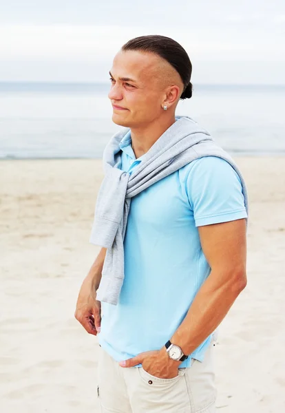 Портрет мужчины на пляже в голубой футболке — стоковое фото