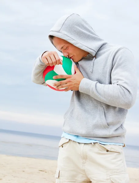 Portret van man die zich voordeed op het strand met bal — Stockfoto