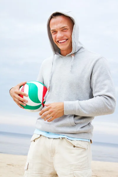 Портрет людини, що позує на пляжі з м'ячем — стокове фото