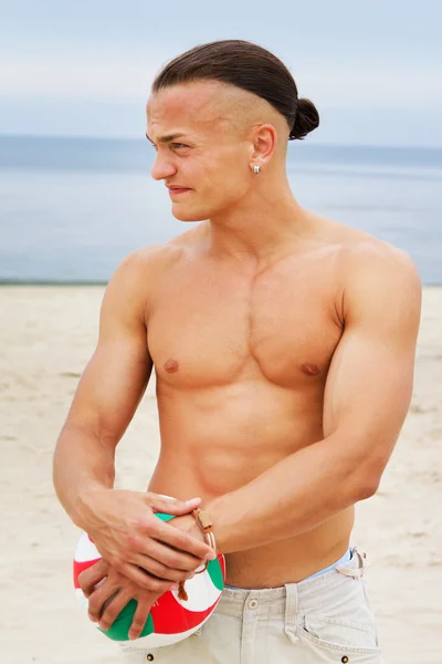 Porträt eines nackten Mannes am Strand mit Ball — Stockfoto