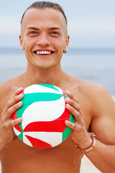 Retrato cercano del hombre sonriente posando en la playa con pelota — Foto de Stock