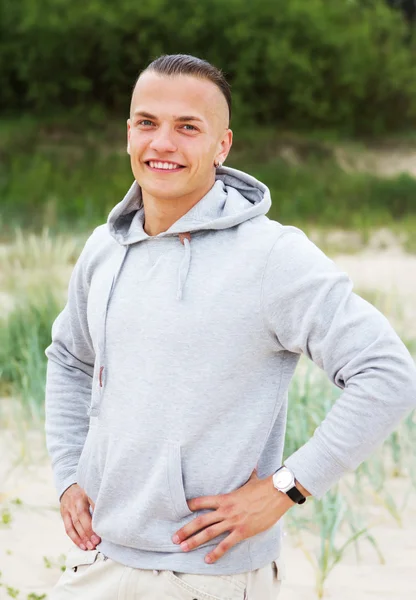 Retrato de homem posando na praia com um casaco — Fotografia de Stock