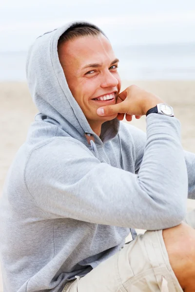 Portret van glimlachende man die zich voordeed op het strand — Stockfoto