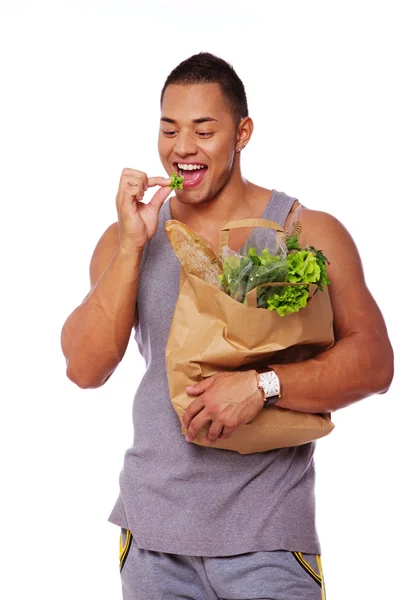 Портрет здорового человека, позирующего в студии с салатом — стоковое фото