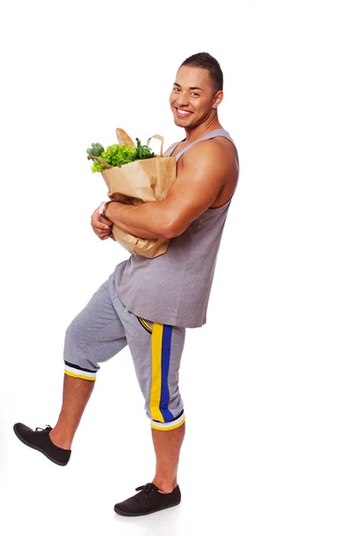 Portrait of muscle man posing in studio with food — Stock Photo, Image