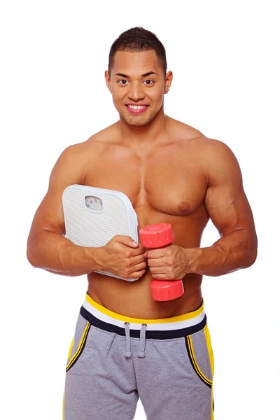 Portrait of muscle man posing in studio with scales — Stock Photo, Image