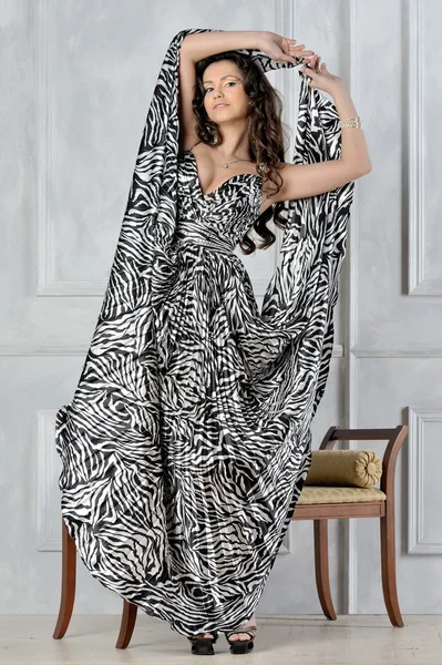 Vacker kvinna i en mycket lång klänning med zebra utskrifter. — Stockfoto