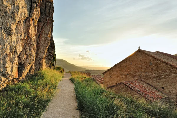 Zachód krajobraz z wielkim wywinięty rock i dachy w arach, Hiszpania — Zdjęcie stockowe