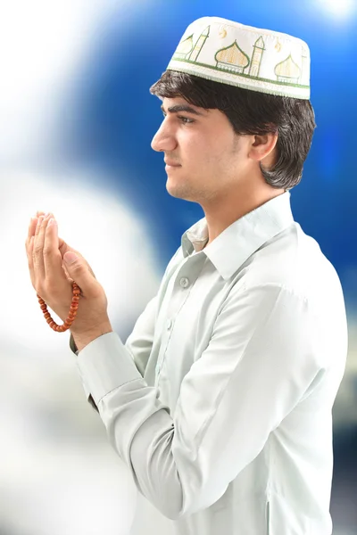 Young man holding a rosary in a pose of praying and asking — Stock Photo, Image