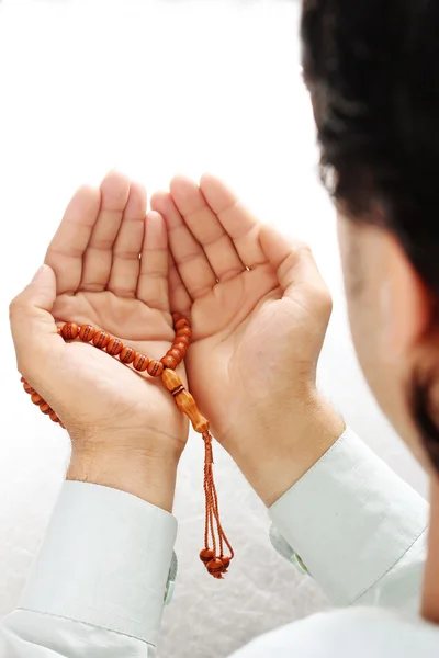 Рука людини тримає розарій в позі молитви і прохання — стокове фото