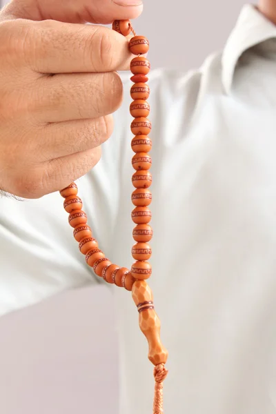 La mano del hombre sosteniendo un rosario en una pose de rezar y pedir — Foto de Stock