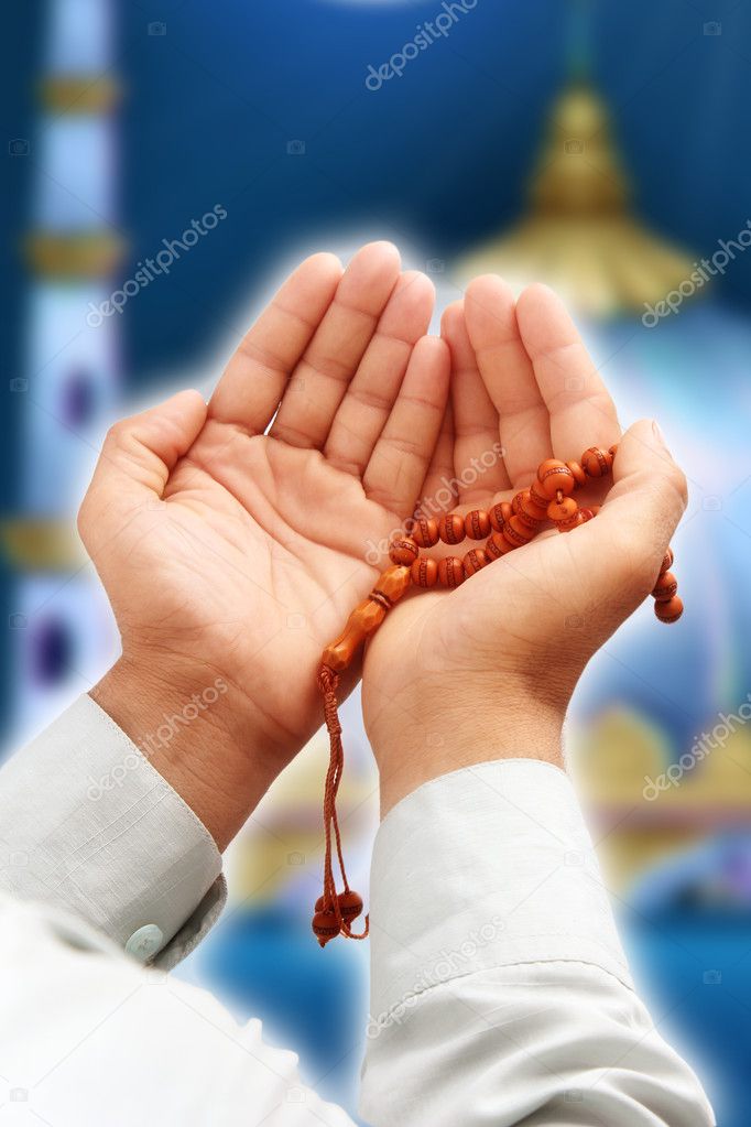 Man's hand holding a rosary in a pose of praying and asking
