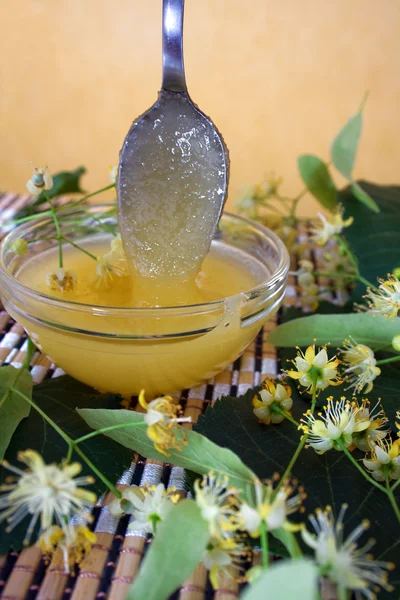 Тарілка з медом і квітами лайма — стокове фото