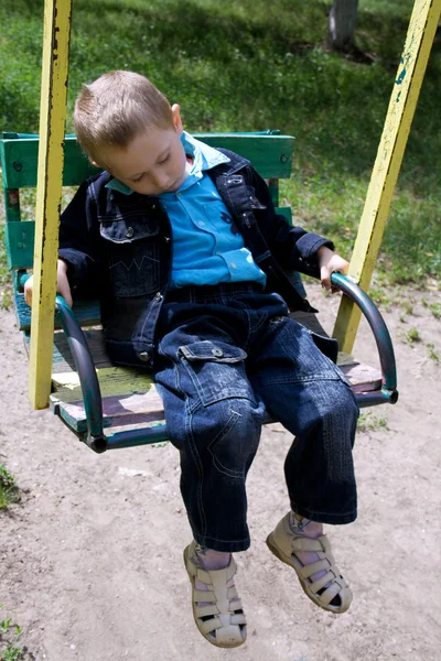 Спящий мальчик на качелях — стоковое фото