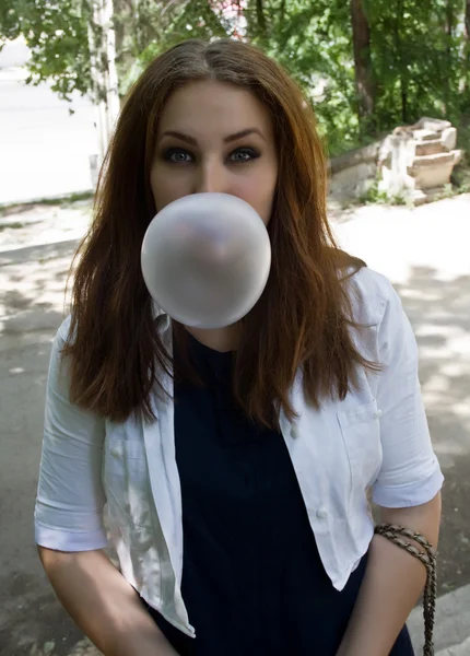 Mooie jonge student meisje blazen zeepbel van kauwgom — Stockfoto