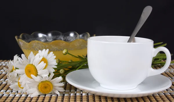 Bouquet van madeliefjes en een kopje thee — Stockfoto