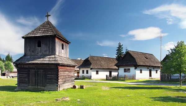 Wooden bell tower and folk houses — Stock Photo, Image