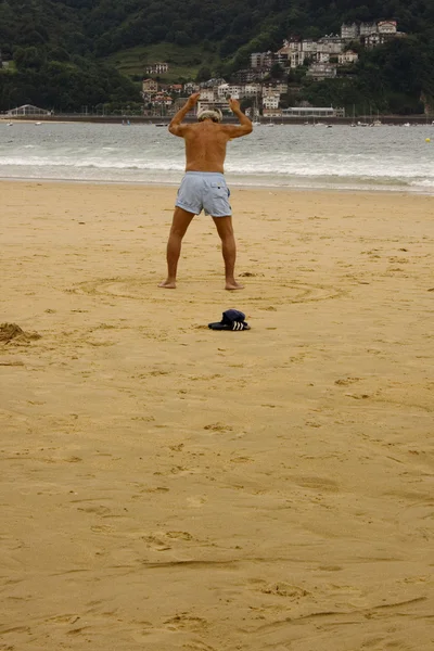 Elder man training in the beach
