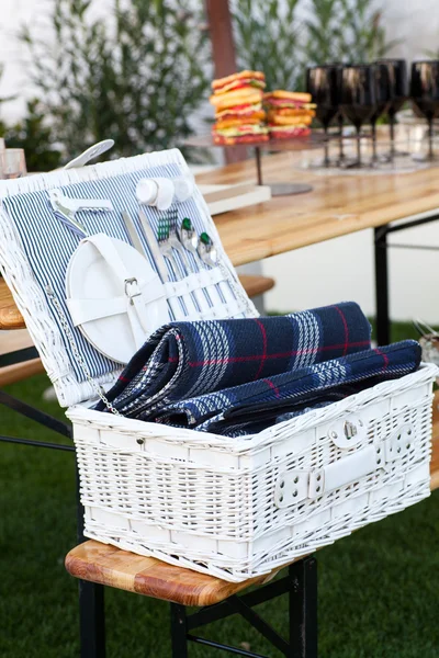 Плетеная корзина с посудой и столовыми приборами — стоковое фото