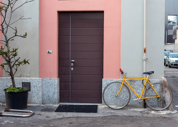 Bicicleta amarela amarrada ao poste — Fotografia de Stock