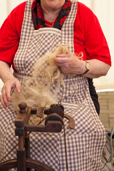 Elderly woman spinning wool — Zdjęcie stockowe