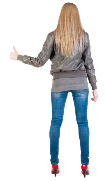 親指を出て立っている若いブロンドの女性の背面図 — ストック写真