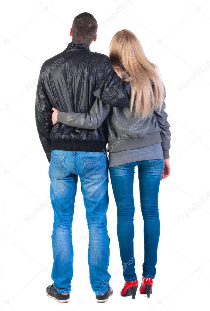 Back view of young couple (man and woman) hug and look into the