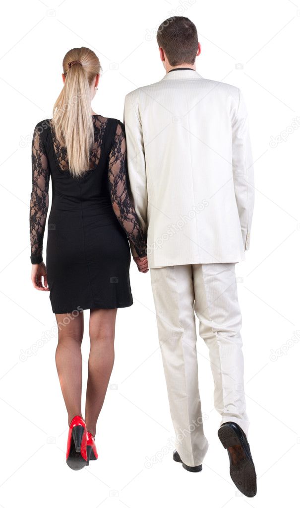 Back view of going young business couple (man and woman) .