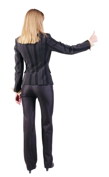 立っている若い金髪のビジネスの女性示す親指の背面図 — ストック写真