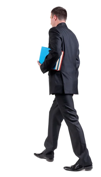 Vista di camminare un uomo d'affari con libri posteriore. — Foto Stock