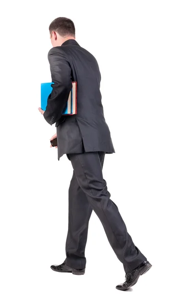 Back view of walking business man with books. — Stock Photo, Image