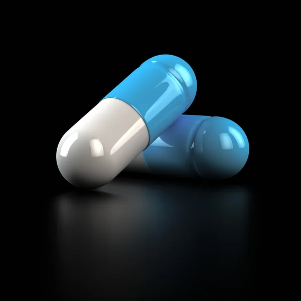 Twee pillen op zwart — Stockfoto