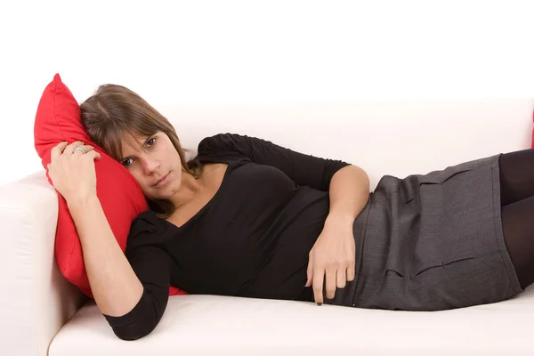 Ung kvinna vilar på soffan — Stockfoto