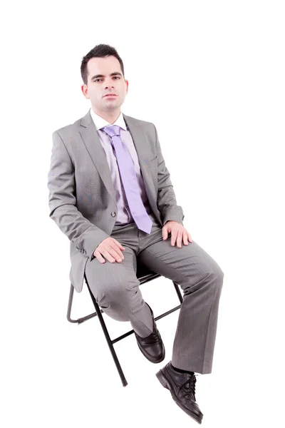 Młody biznes człowiek siedzi na krześle — Zdjęcie stockowe