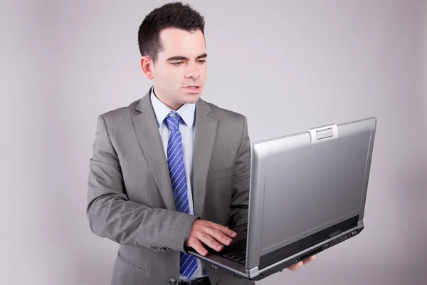 Jeune homme d'affaires travaillant avec un ordinateur portable Photos De Stock Libres De Droits