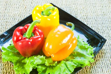 Bulgarian sweet pepper of red and yellow color and leaves of let clipart