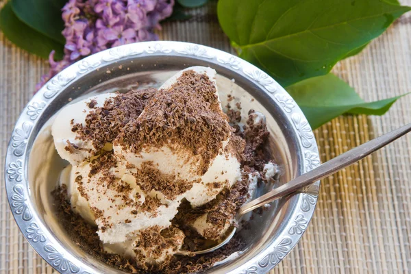 Zoet dessert met de geraspte chocolade en boeket van lila — Stockfoto