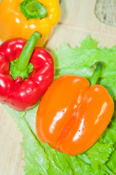 Bulharské papriky červené a žluté barvy a listy nechte — Stock fotografie