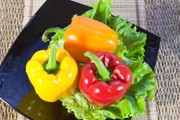 Bulgarian sweet pepper of red and yellow color and leaves of let — Stock Photo, Image