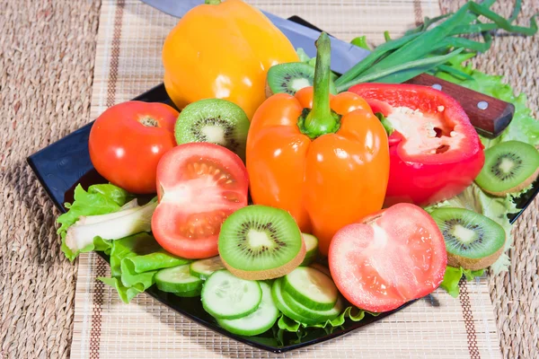Gekleurde groenten en fruit liggen op een schotel — Stockfoto