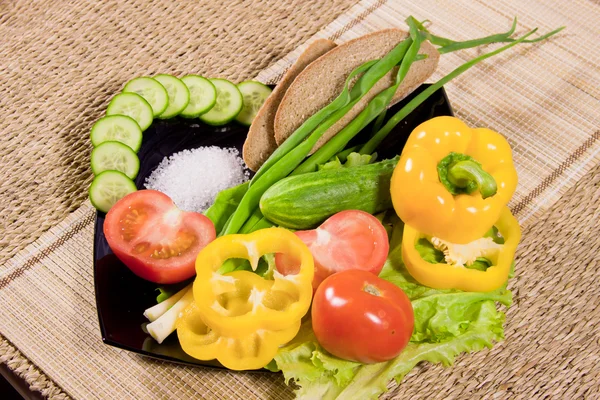Verdure con vegetazione, pane di segale e grande sale su un piatto — Foto Stock
